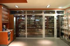 Akademia inspiracji Makro. Humidor dla win i stanowisko sommelierów. Humidor i tuż obok stanowisko sommeliera z podręcznymi kieliszkami. Stół wyposażony w zmywarkę i zlew. Po prawej na regale wybór dostępnych  w Makro kieliszków i pucharów. 