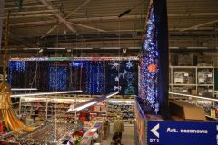 Ekspozycja Handlowa Boże Narodzenie. Makro C&C. Ściana świateł. Świąteczne światełka wyeksponowane na granatowym tle, podwieszone u stropu hali. Bezlik możliwych do kupienia zestawów świateł wprost oszałamiał. Projekt stoiska i nadzór Tatjana Kobuszewska