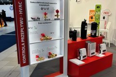 Ekspozycja targowa prezentuje produkty do kontroli przepływu HVAC marki CAREL. Stoisko przedstawia elektroniczne zawory rozprężne, oznakowane w języku polskim, na trzech półkach z opisami. W tle znajdują się czarno-białe urządzenia HVAC, znaki i duże logo XL. projekt i nadzór Tatjana Kobuszewska trksystem.com