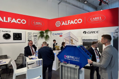 Stoisko na targach prezentuje marki ALFACO i CAREL na czerwonych banerach. Kilku mężczyzn w garniturach rozmawia przy stolikach. Na pierwszym planie znajduje się niebieski wyświetlacz DX STREAM. Zdjęcia produktów i rośliny zdobią białe ściany. Otoczenie jest jasne i nowoczesne. projekt i nadzór Tatjana Kobuszewska trksystem.com