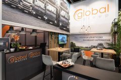 Stoisko targowe Global Motion w Ptak Warsaw Expo obejmuje markowe lady, strefę wypoczynkową z jedzeniem, oznakowanie ścienne i ekspozycje promocyjne dla logistyki w branży motoryzacyjnej. projekt i nadzór Tatjana Kobuszewska trksystem.com