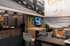 Stoisko targowe Global Motion na Ptak Warsaw Expo z firmowymi oznaczeniami, strefą do siedzenia, dużym zdjęciem ciężarówek na ścianie oraz informacjami o firmie w języku polskim. projekt i nadzór Tatjana Kobuszewska trksystem.com