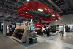 Stoisko targowe dla firmy Gondella na targach Hala EXPO XXI, obejmujące regały, kasy samoobsługowe, próbki produktów i miejsce do siedzenia, z interakcją odwiedzających i nowoczesnym oświetleniem nad głową. projekt i nadzór Tatjana Kobuszewska trksystem.com
