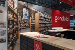 Na targach targi Retail Show w Hali EXPO XXI, stoisko targowe Gondella prezentuje półki z produktami, blat z broszurami i ścianę z dużym obrazem alejki supermarketu. projekt i nadzór Tatjana Kobuszewska trksystem.com