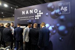 Grupa mężczyzn w garniturach gromadzi się wokół stoiska z napisem "NANO" i "Ag Silver" w Expo XXI podczas targów Forum Szefów Kuchni i Restauracji. projekt i nadzór Tatjana Kobuszewska trksystem.com