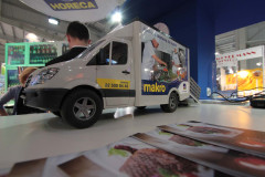 Miniaturowy model samochodu dostawczego Makro jest wystawiony na stole obok broszur w stoisku targowym Makro CC podczas targów Eurogastro. projekt i nadzór Tatjana Kobuszewska trksystem.com