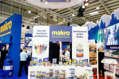 Stoisko wystawowe Makro na targach targi Eurogastro z różnymi produktami spożywczymi w puszkach i opakowaniach, znakami promocyjnymi i dużym okrągłym banerem. projekt i nadzór Tatjana Kobuszewska trksystem.com