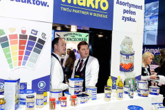 Stoisko na targach targi Eurogastro prezentuje różnorodne produkty spożywcze w puszkach, z dwoma mężczyznami za ladą; widoczne są polskie znaki i logo stoiska targowego Makro CC. projekt i nadzór Tatjana Kobuszewska trksystem.com