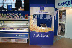 Stoisko promocyjne Frytki Express z wizerunkiem frytek, obok zamrażarki eksponującej produkty mrożone w stoisku targowym Makro CC podczas targów Eurogastro w otoczeniu sklepowym lub wystawienniczym. projekt i nadzór Tatjana Kobuszewska trksystem.com