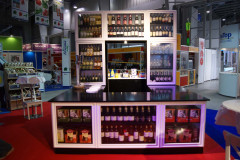 Stoisko targowe Makro CC z barem prezentującym butelki wina i alkoholi, otoczone regałami z napojami, idealnie wpisuje się w atmosferę targów Eurogastro organizowanych w przestrzeni hali wystawienniczej. projekt i nadzór Tatjana Kobuszewska trksystem.com
