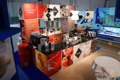 Stoisko targowe Makro CC w targi Eurogastro prezentuje ekspresy do kawy, napoje i materiały marki Rioba, zawierające menu koktajli i kawy wraz z kolorowymi zdjęciami napojów i ludzi. projekt i nadzór Tatjana Kobuszewska trksystem.com