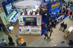 Widok z lotu ptaka na ruchliwe targi, targi Eurogastro, z dużym stoiskiem targowym Makro CC, żywymi ekspozycjami produktów, spacerującymi gośćmi i mniejszymi stoiskami w pobliżu. projekt i nadzór Tatjana Kobuszewska trksystem.com