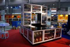 Stoisko targowe Makro CC na targach Eurogastro prezentuje różnorodne butelki alkoholi na półkach i w gablotach, z centralną ladą oraz firmowymi banerami w tle. projekt i nadzór Tatjana Kobuszewska trksystem.com