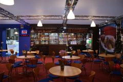 Stoisko targowe Makro. Widok wydzielonego miejsca spotkań w którym zaproszonym gościom serwowano przekąski i napoje. Stoisko z napojami \"żyło\" i cieszyło się powodzeniem u zaproszonych gości.