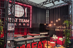 Stoisko targowe ma czarno-czerwoną kolorystykę z neonami. Obok logo w kształcie kuli ziemskiej widnieje duży napis "MEAT TEAM". Są tam kanapy, wiszące światła, rośliny, lada w stylu baru i odważny napis MEATTEAM z przodu. projekt i nadzór Tatjana Kobuszewska trksystem.com