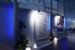 Stoisko wystawowe z osią czasu Nilfisk Advance, roślinami w pomieszczeniach, okrągłymi lampami podłogowymi i panelami wystawowymi w nowoczesnym, dobrze oświetlonym otoczeniu. projekt i nadzór Tatjana Kobuszewska trksystem.com