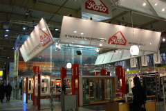 Stoisko wystawowe firmy Koło obejmuje podwójne stoisko z dużymi napisami w języku polskim i angielskim, witryny sklepowe obejmujące okno dachowe oraz oświetlenie pod wysokim sufitem w przestronnym, nowoczesnym centrum kongresowym. projekt i nadzór Tatjana Kobuszewska trksystem.com