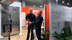 Stoisko smeg ma czerwono-biały branding, tablice z tekstem, rośliny doniczkowe i drewnianą podłogę. projekt i nadzór Tatjana Kobuszewska trksystem.com