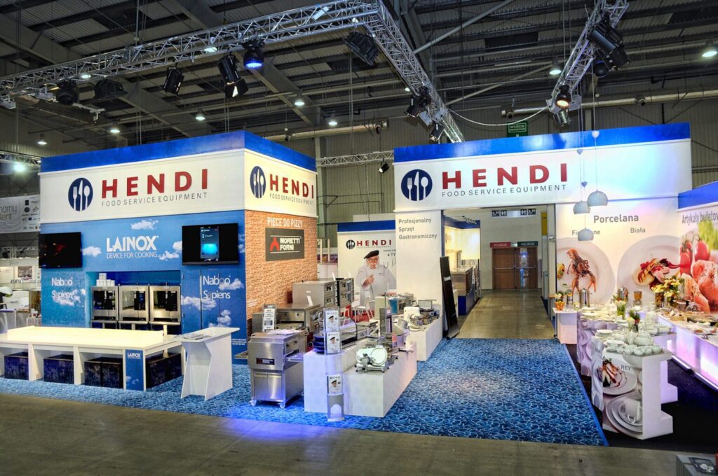 Stoisko targowe Hendi Food Service Equipment, prezentujące sprzęt kuchenny i sprzęt ze stali nierdzewnej, zaprojektowane z niebieskim brandingiem i jasnym oświetleniem. projekt i nadzór Tatjana Kobuszewska trksystem.com