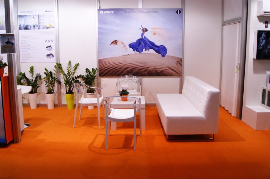 Strefa rozmów na stoisku Gree: sofa, krzesła i stolik pod grafiką wielkoformatową, Forum Wentylacja 2014