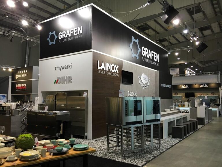 Nowoczesne stoisko wystawowe GRAFEN Future Equipment, z dużymi szyldami, urządzeniami kuchennymi i zestawem jadalnym z talerzami i sztućcami. Na stoisku prezentowane są takie marki jak Lainox, DIHR i Zmywarki. Projekt Tatjany Kobuszewskiej, TRK System.
