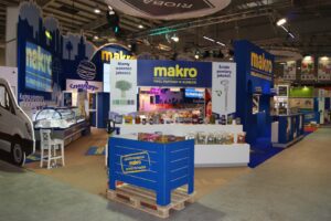 Stoisko targowe dla Makro z ekspozycją żywności, próbkami produktów, oznakowaniem marki i różnymi ladami w wewnętrznym oświetleniu wystawienniczym w stoisku targowym Makro CC podczas targów Eurogastro. projekt i nadzór Tatjana Kobuszewska trksystem.com