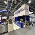 Stoisko TECHNICA firmy Technica Group prezentuje komercyjny sprzęt kuchenny na stoisku targowym, z niebiesko-białym brandingiem, urządzeniami ze stali nierdzewnej, jasnym oświetleniem i sąsiednimi stoiskami, takimi jak Délifrance. projekt i nadzór Tatjana Kobuszewska trksystem.com