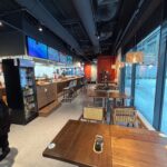 Nowoczesna kawiarnia Halo Mian łączy przytulną atmosferę z eleganckim stylem - drewniane stoły, czarny sufit z odsłoniętymi rurami, stołki barowe przy ladzie i duże okna wypełniają tę restaurację chińską światłem dziennym i ciepłem. projekt i nadzór Tatjana Kobuszewska trksystem.com