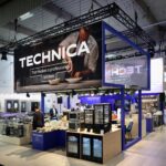 Nowoczesne stoisko wystawiennicze na targach Eurogastro i Ptak Warsaw Expo prezentuje profesjonalne urządzenia kuchenne pod dużym napisem TECHNICA ze zdjęciem szefa kuchni. Ludzie oglądają piekarniki i lodówki w dobrze oświetlonej, zorganizowanej przestrzeni z wysokimi sufitami. projekt i nadzór Tatjana Kobuszewska trksystem.com