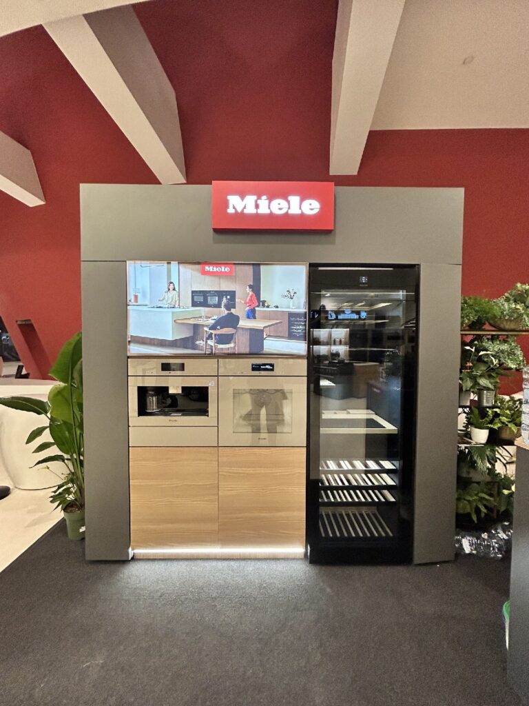 Ekspres do kawy Miele CVA 7845 pod podświetlanym kasetonem z towarzystwem gotującym — mikrostoisko Miele Interioro Design Days