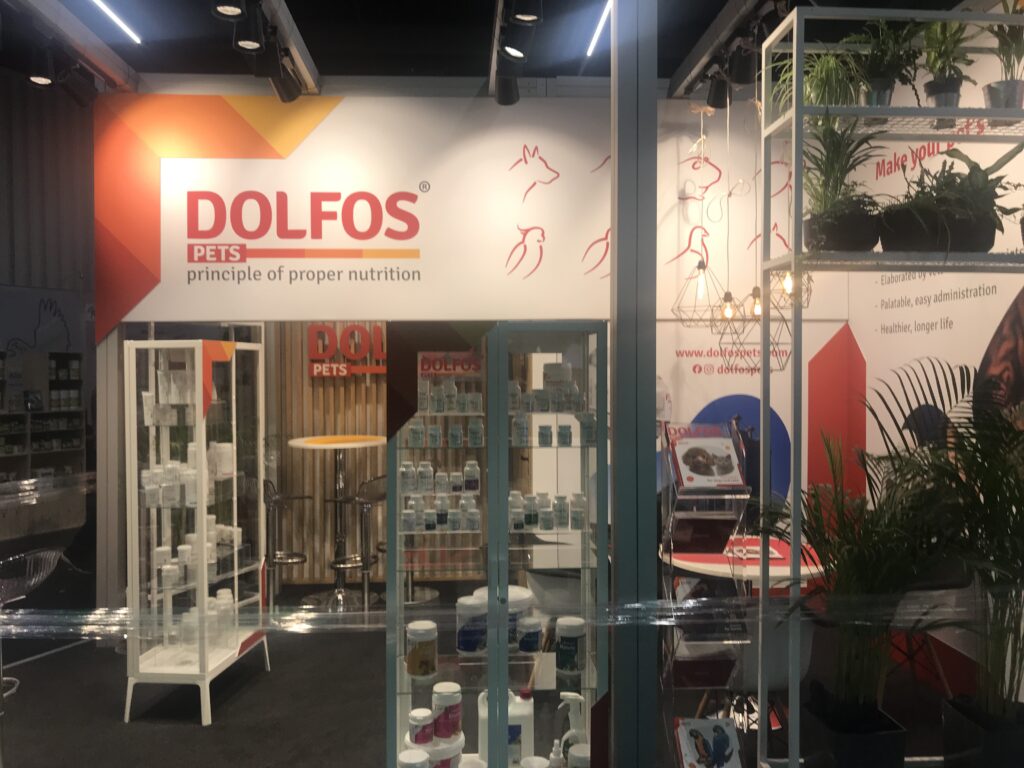 Suplementy dla zwierząt. Narożne stoisko targowe Dolfos na Interzoo w Norymberdze (Niemcy) — branża zoologiczna, dostęp z dwóch stron. Projekt Tatjany Kobuszewskiej, TRK System