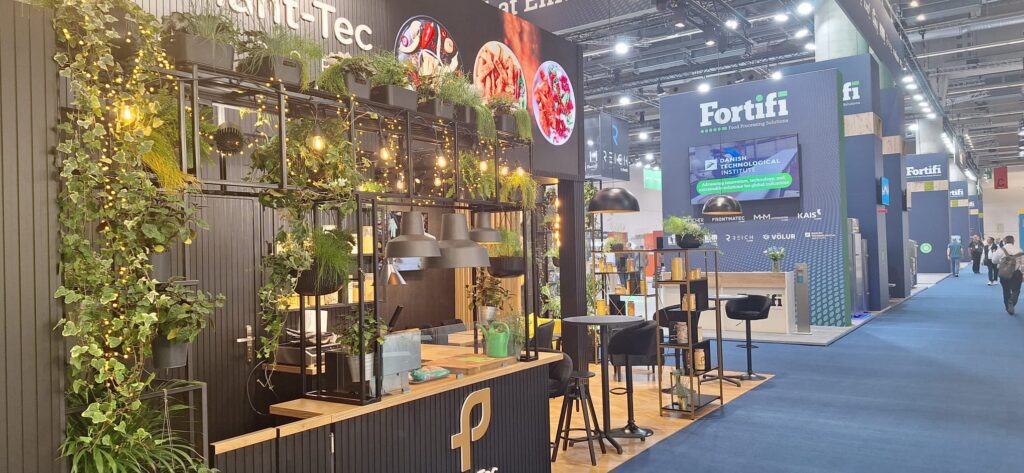 Stoisko targowe Plant-Tec Europe na IFFA we Frankfurcie — narożna zabudowa z ogrodem wertykalnym. Projekt Tatjany Kobuszewskiej, TRK System