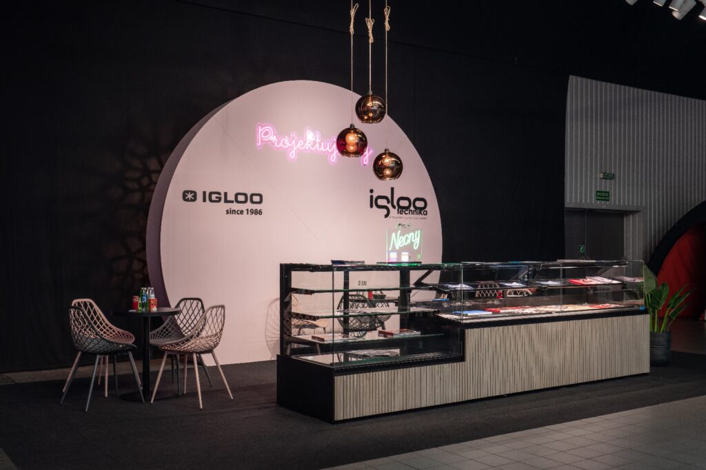 Nowoczesna ekspozycja deserów na targach Expo Sweet w Warszawie, z szklaną ladą i neonowym napisem „Pasjotkijs”. Stylowe stoisko firmy Iglootechnika na targach Expo Sweet prezentuje marki „IGLOO” i „Navy” w przejrzystej, zachęcającej oprawie. projekt i nadzór Tatjana Kobuszewska