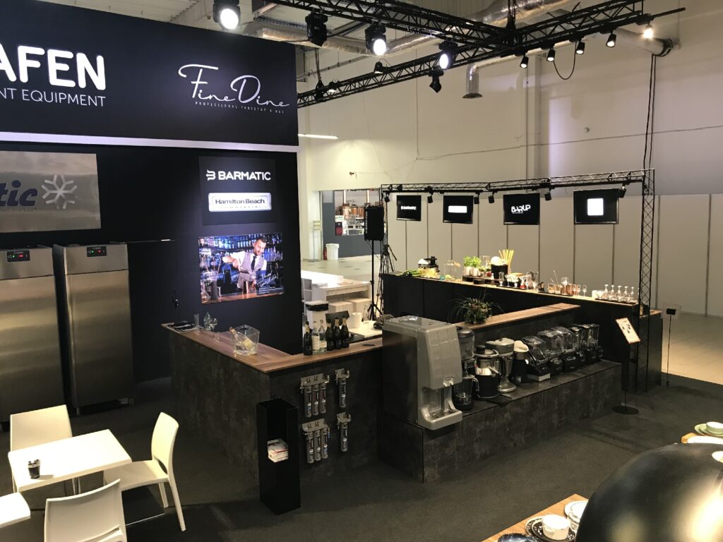 Na nowoczesnym stoisku wystawowym prezentowany jest sprzęt kuchenny.