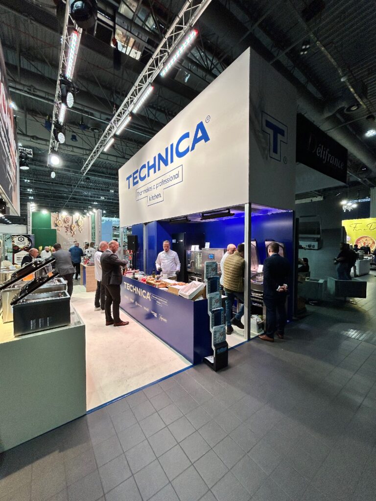 Stoisko targowe firmy TECHNICA prezentuje kucharzy przy stoisku Technica podczas Kongresu Szefów Kuchni, gdzie pracownicy i goście nawiązują kontakt przy urządzeniach kuchennych. Nowoczesne, niebiesko-białe stoisko eksponuje wizerunek marki i prezentuje produkty w jasnym oświetleniu przestronnej hali. projekt i nadzór Tatjana Kobuszewska