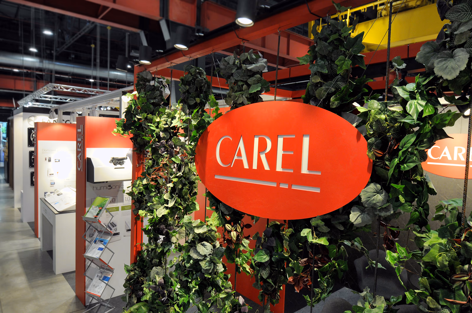 Zielona ściana z żywego bluszczu na stoisku targowym Alfaco z podświetlonym logo Carel, 2020