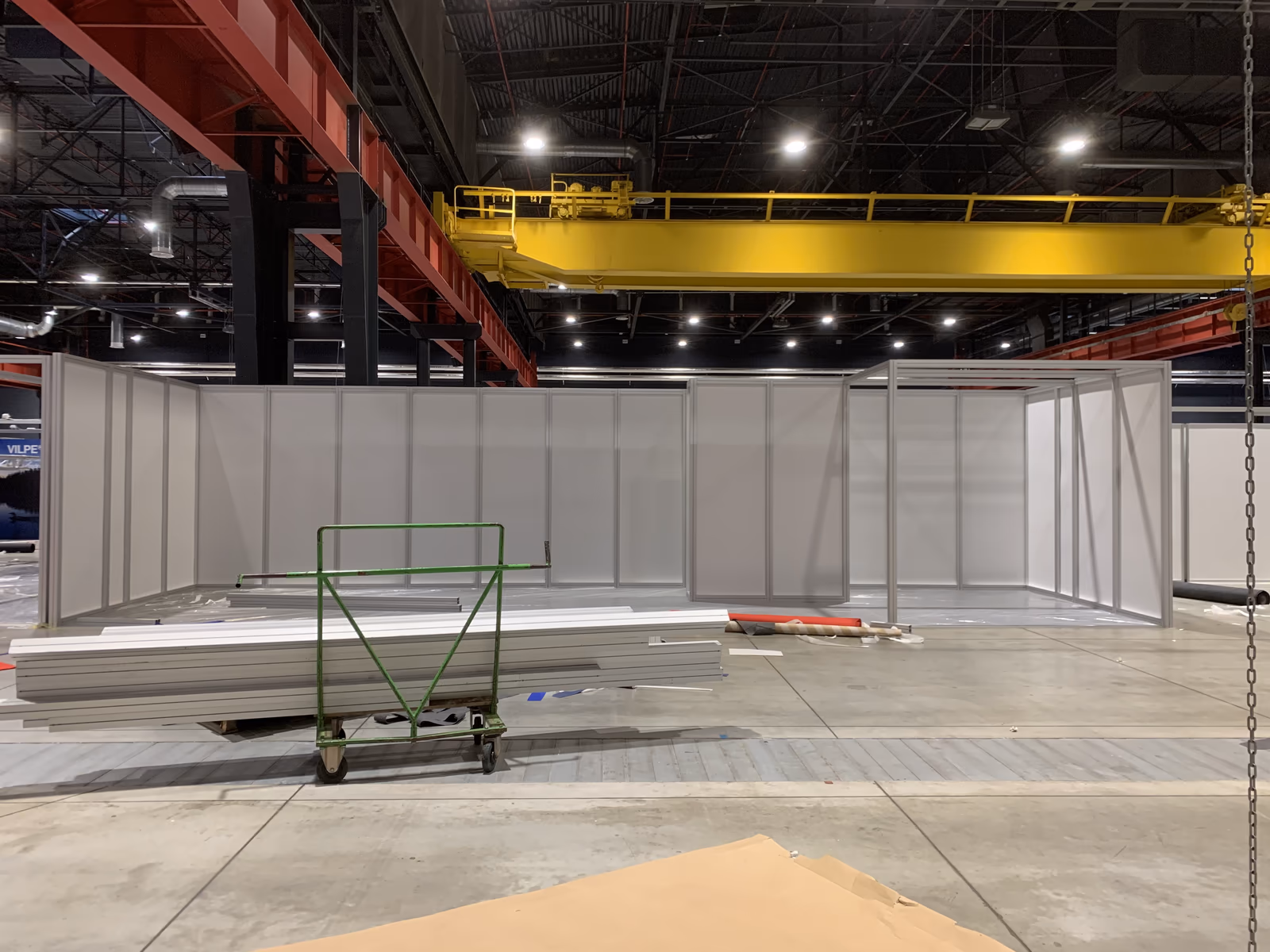 Hala Global EXPO przed montażem, same białe ścianki systemowe, czerwone dźwigary i żółta suwnica, 2020