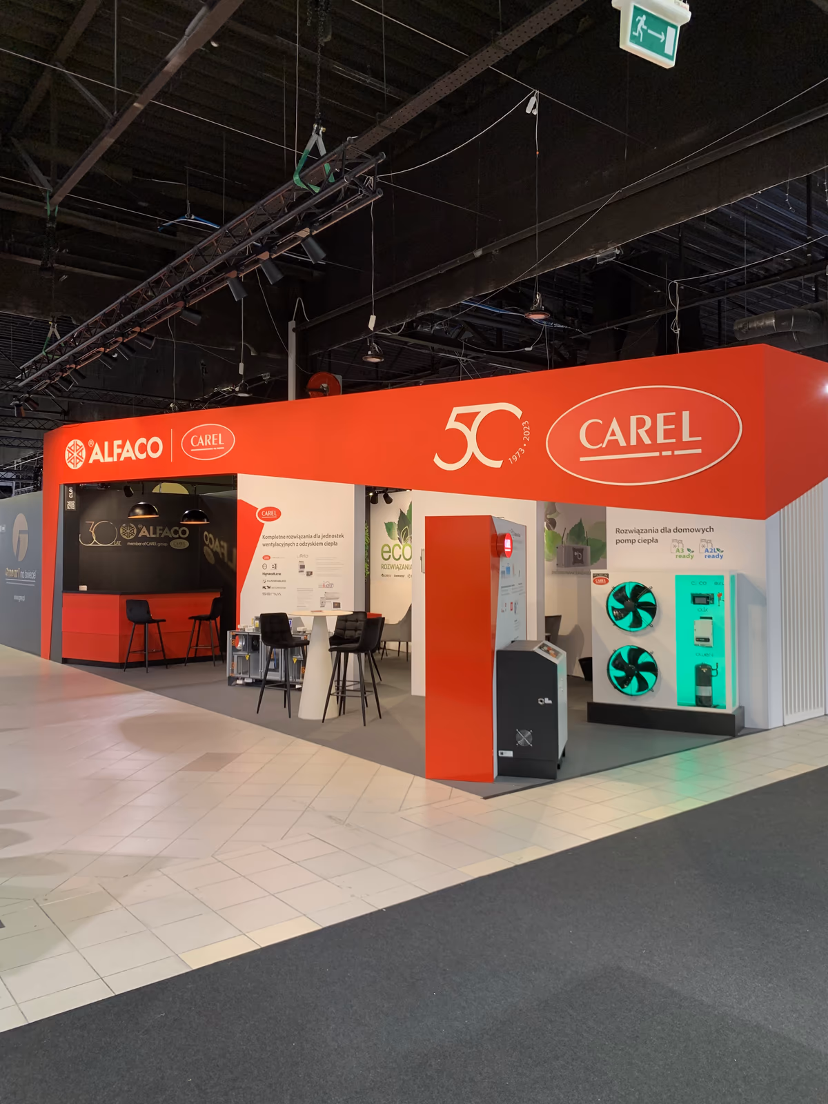 Stoisko targowe Alfaco i Carel 52 m² na targach HVAC 2023, czerwony fryz z jubileuszem 50 lat Carel i ekspozytor pompy ciepła