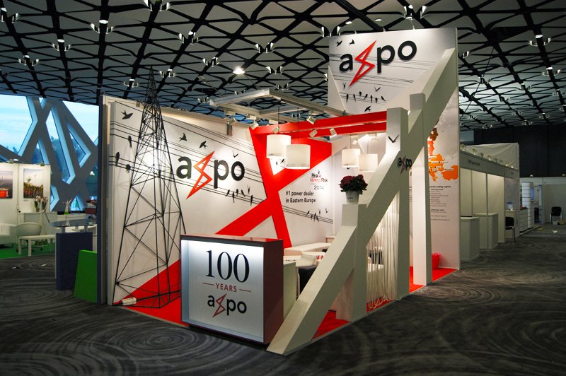 Biało-czerwone stoisko z ukośną belką i logo Axpo, obok strefa z siedziskami