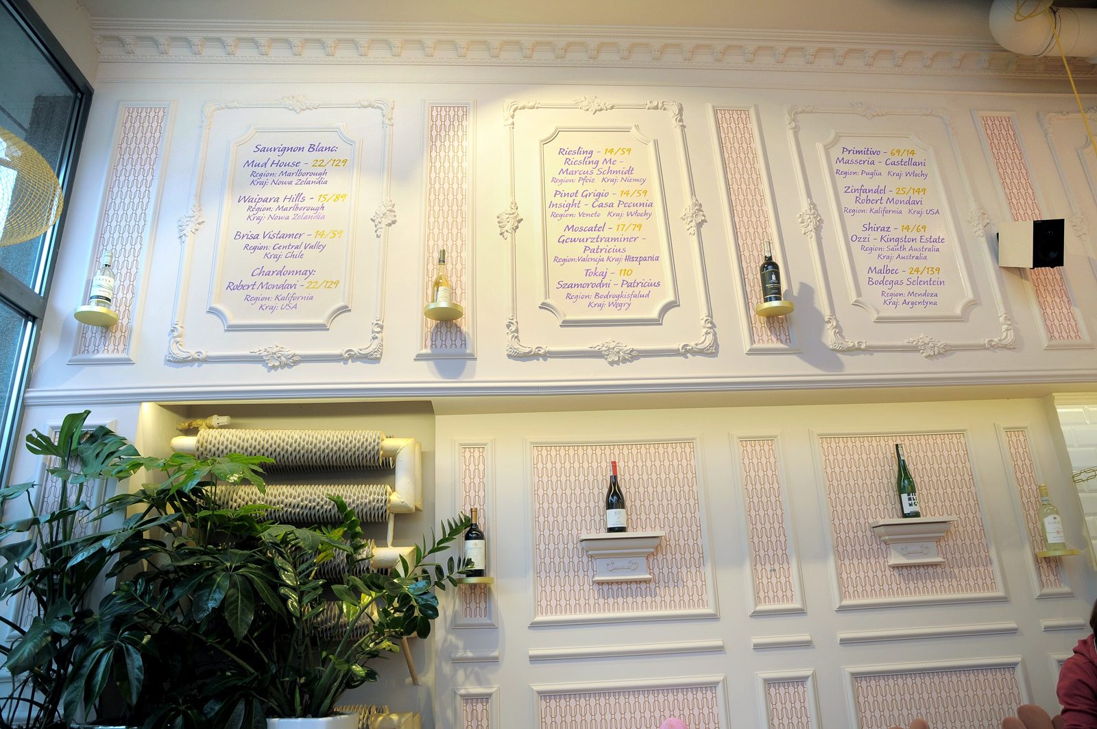 Menu wypisane ręcznie na ścianie pokrytej sztukaterią