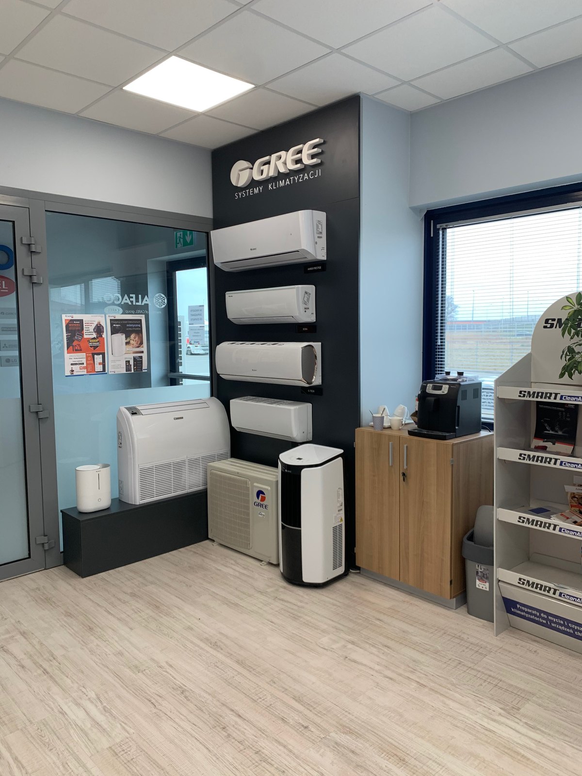 Gotowy showroom Alfaco: jasna ściana z ladą, ciemna ściana pionowa i jasna podłoga drewnopodobna