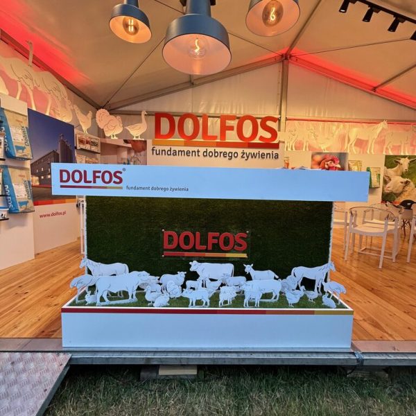 Stoisko reklamowe Dolfos z sylwetkami zwierząt na trawie, podświetlanymi lampami sufitowymi oraz napisami z nazwą i hasłem firmy w języku polskim tworzy efektowne stoisko wystawiennicze. projekt i nadzór Tatjana Kobuszewska trksystem.com